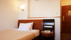 Letto singolo accanto alla porta d’ingresso della camera