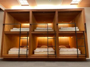 Compartimentos de literas de madera con colchones y ropa de cama