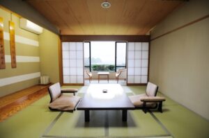 窓際に低いテーブルと椅子がある畳の客室