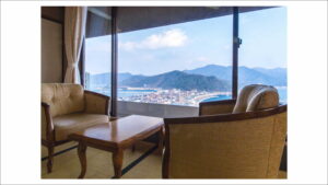 Stühle und Tisch am Fenster mit Blick auf die Stadt und das Meer