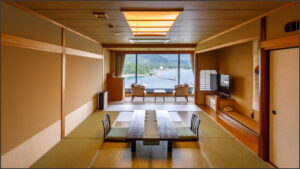 Tatamizimmer mit niedrigem Tisch und Stühlen am Fenster