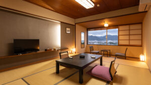 Habitación de tatami con mesa baja, sillas de suelo y vista por la ventana