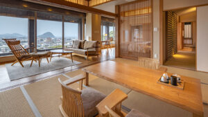 Habitación de tatami con mesa de madera, sillas y asientos junto a la ventana