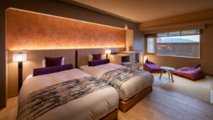 Camas individuales en una habitación con zona de estar de tatami