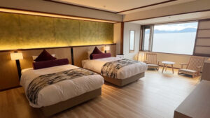 Camas individuales en una habitación con asientos junto a la ventana