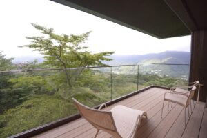 Balcon avec chaises longues surplombant des montagnes boisées