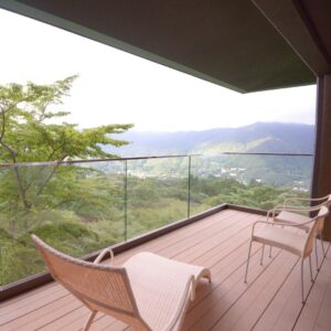 Vue sur la montagne depuis le balcon avec chaises et garde-corps en verre