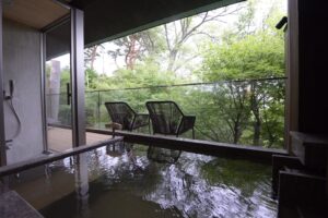 Bain privé à côté d’un balcon ouvert avec vue sur la forêt