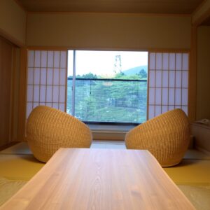 Deux chaises tressées et une table basse près de la fenêtre shoji