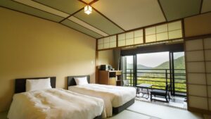 Camas individuales en una habitación con vista desde el balcón