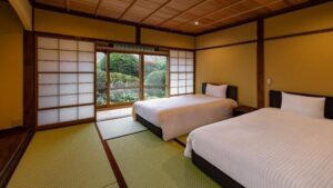 Dos camas en una habitación de tatami con puertas shoji