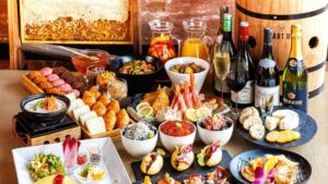 Bufé con aperitivos, sushi y botellas de vino