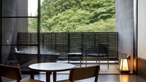 Baño al aire libre junto a asientos en el balcón con vista al bosque