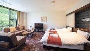 Chambre avec lit, coin salon avec canapé et vue par la fenêtre