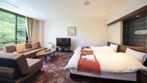 Chambre avec grand lit et coin salon avec canapé