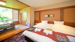 Lits jumeaux dans une chambre de ryokan avec coin salon en tatami