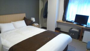 客室のデスクと窓のそばにあるダブルベッド