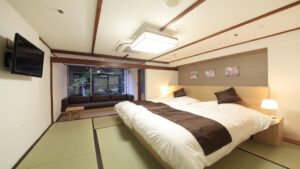 窓際の腰掛けがある畳の客室のツインベッド