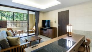 Living area with sofa, TV, and balcony chairs