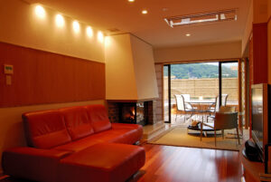 Chambre avec canapé rouge et table de balcon avec chaises