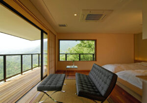 Chambre avec fauteuils de détente, lit et vue depuis le balcon