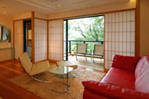 Canapé et chaises dans la chambre face à la verdure du balcon