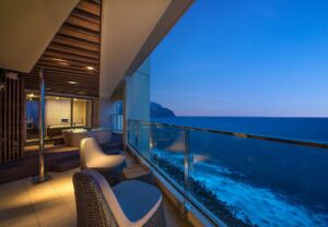 Baignoire sur le balcon et chaises avec vue sur l’océan au crépuscule