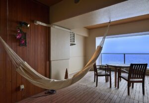 Balcon avec hamac, table, chaises et vue sur l’océan