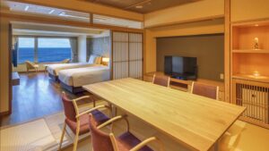 Chambre avec lits, table à manger et vue sur l’océan