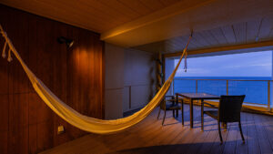 Hamac et table sur la terrasse d’une chambre avec vue sur la mer