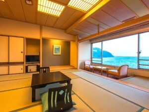 Chambre en tatami avec table basse et chaises avec vue sur l’océan