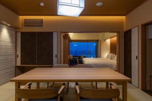 Chambre en tatami avec table et lits près de la fenêtre