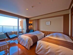 Lits jumeaux à côté d’un balcon avec vue sur l’océan