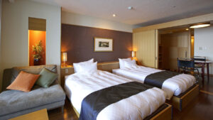 Lits jumeaux à côté d’un canapé dans une chambre