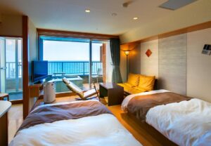 Deux lits simples dans une chambre d’hôtes avec balcon et vue sur l’océan