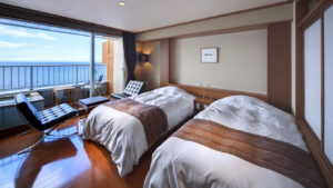 Lits jumeaux dans une chambre avec balcon et vue sur l’océan