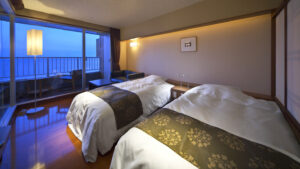 Deux lits dans une chambre près de la fenêtre