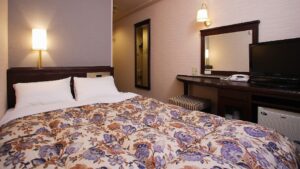 Cama doble con edredón estampado en la habitación