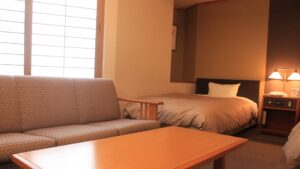 Dormitorio con cama individual, sofá y mesa baja