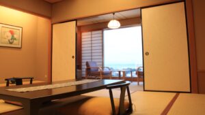 Habitación de tatami con mesa baja y sillas junto a la ventana