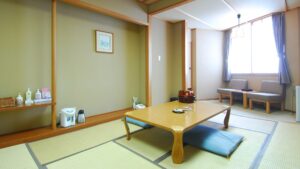Habitación de tatami con mesa baja y asientos junto a la ventana