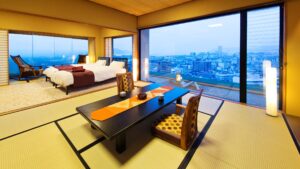 Chambre en tatami avec table basse, lits et vue sur la ville