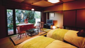 Lits jumeaux dans une chambre en tatami avec patio sur jardin