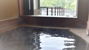 開いた窓辺にある、屋外の景色を望む貸切風呂