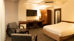 配有床、书桌和两把扶手椅的客房