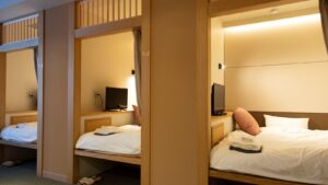 三个睡眠区，配有整理整齐的床铺和电视