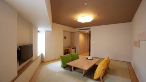 低いテーブル、座椅子、テレビのある畳の部屋