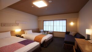 客室のツインベッドとソファ