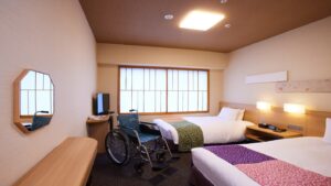 車椅子が置かれたバリアフリー客室のツインベッド