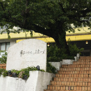 大きな木の下の入り口看板と階段